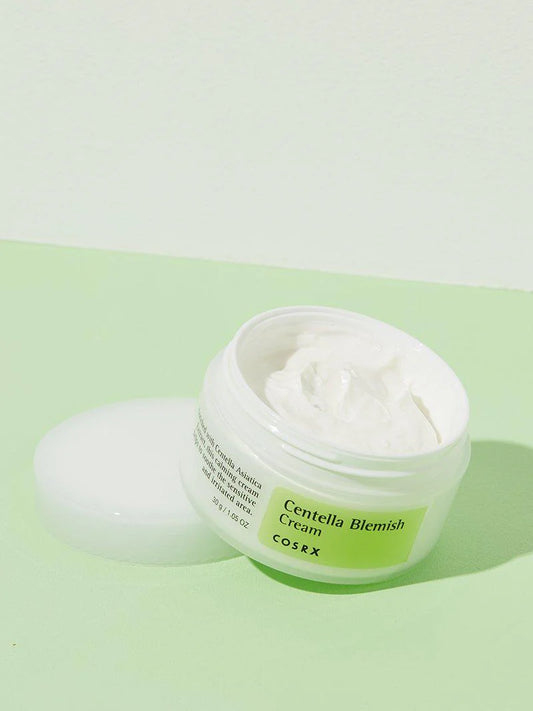A small amount of COSRX Blemish Cream squeezed onto a finger, showing its lightweight, non-greasy white texture.
