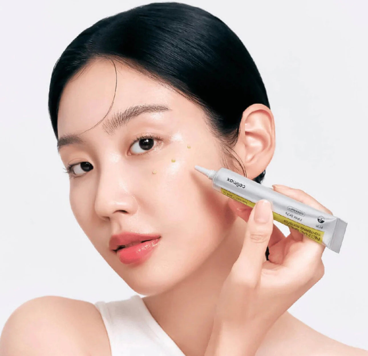 Applying the Celimax Tightening Booster serum for deep absorption and firming