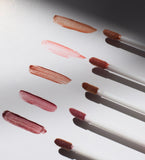 Lipstick applicators with swatches of red and pink lipstick on a white background