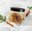 Jar of carrot carotene product with carrots and green leaves on a white background