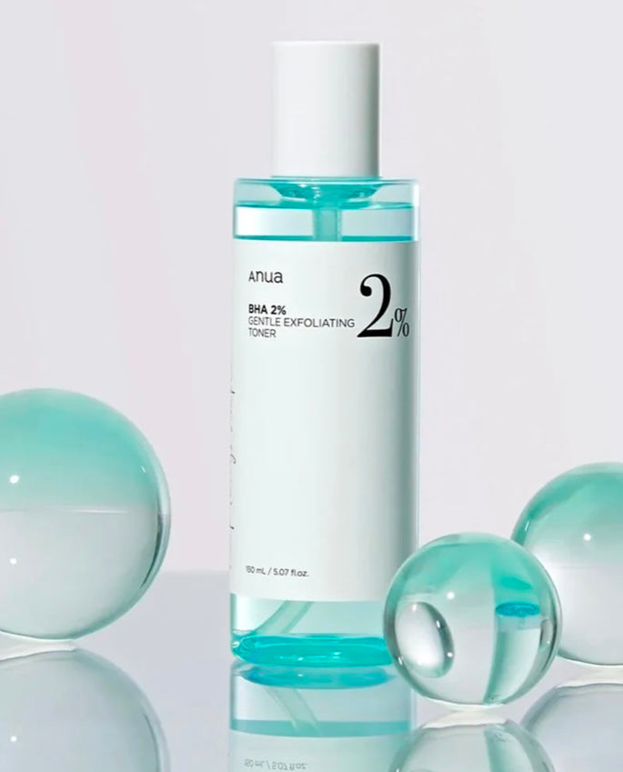 The clear, water-like texture of the Anua BHA gentle exfoliating toner on cotton pad.