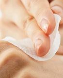 Person gently swiping an original clear pad cosrx on their cheek for a quick skincare step.