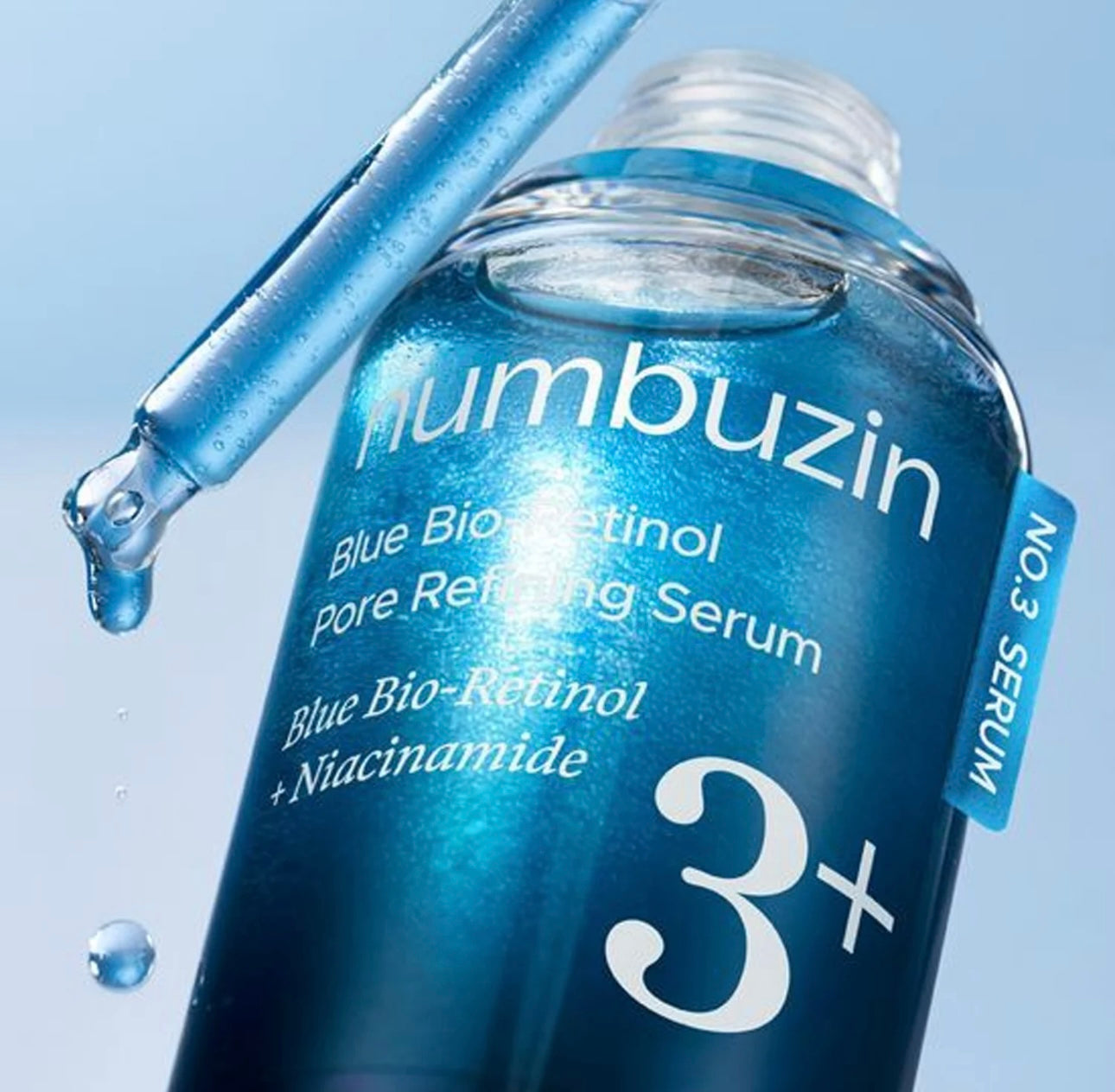 Woman gently applying the Numbuzin No. 3 serum to her cheek for pore care.