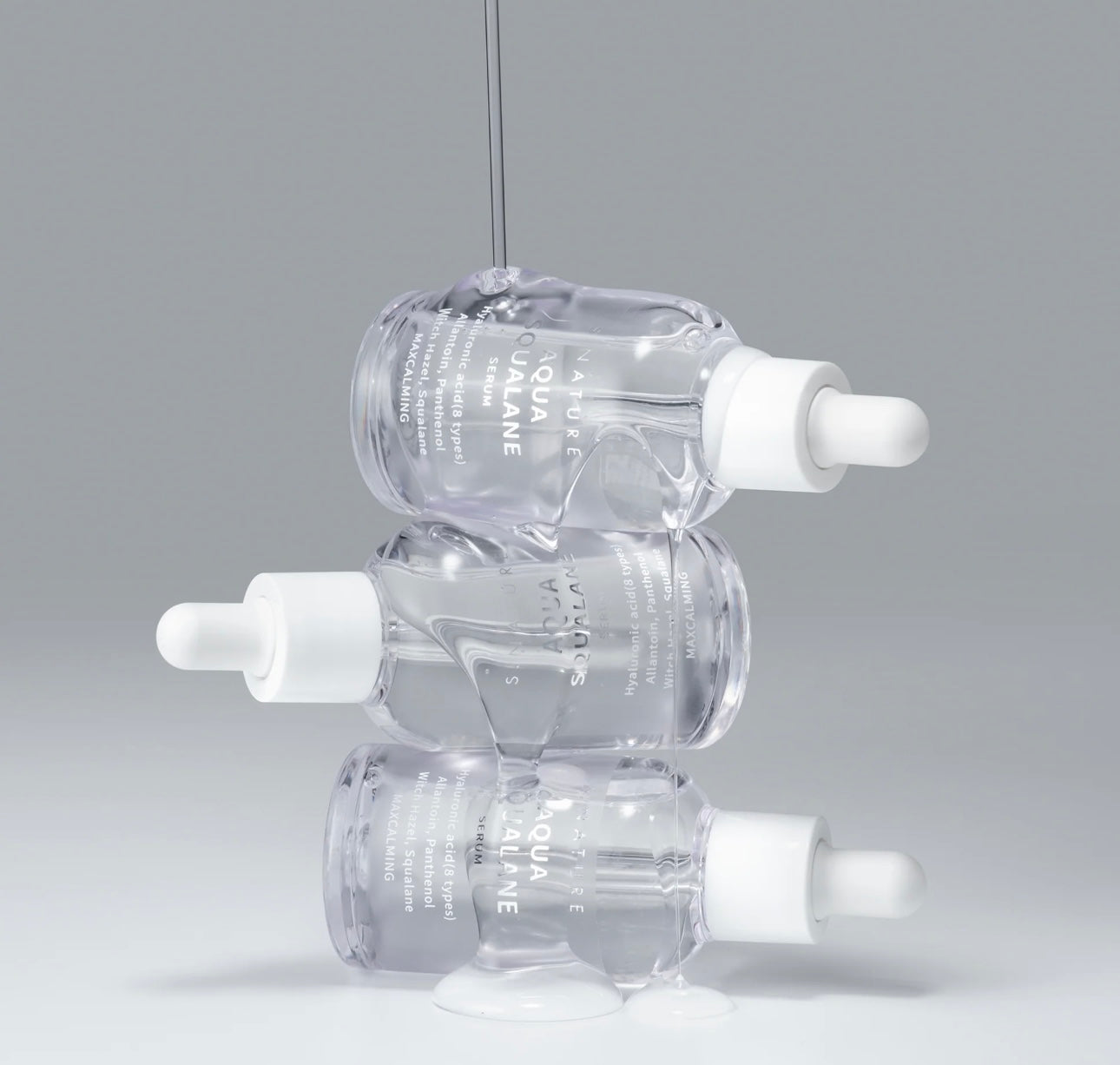 Close up of the Aqua Squalane serum texture dripping from a dropper showing its lightweight and hydrating consistency.