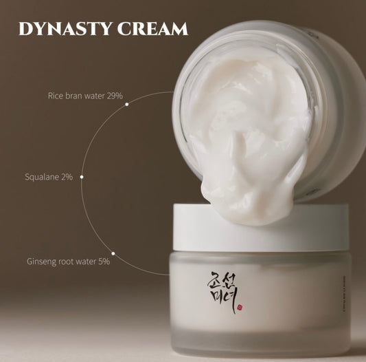 Open jar of Beauty of Joseon Dynasty Cream showing its rich white cream texture. The label on the jar and the spoonful of cream emphasize key ingredients like ginseng and honey.