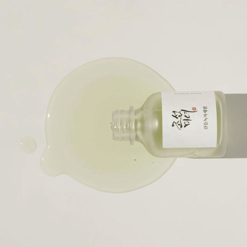 A drop of the Beauty of Joseon calming serum with green tea panthenol being applied to the skin, showing its clear, lightweight texture.