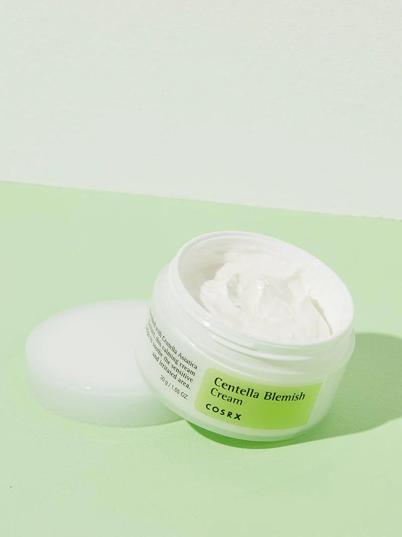 A small amount of COSRX Blemish Cream squeezed onto a finger, showing its lightweight, non-greasy white texture.