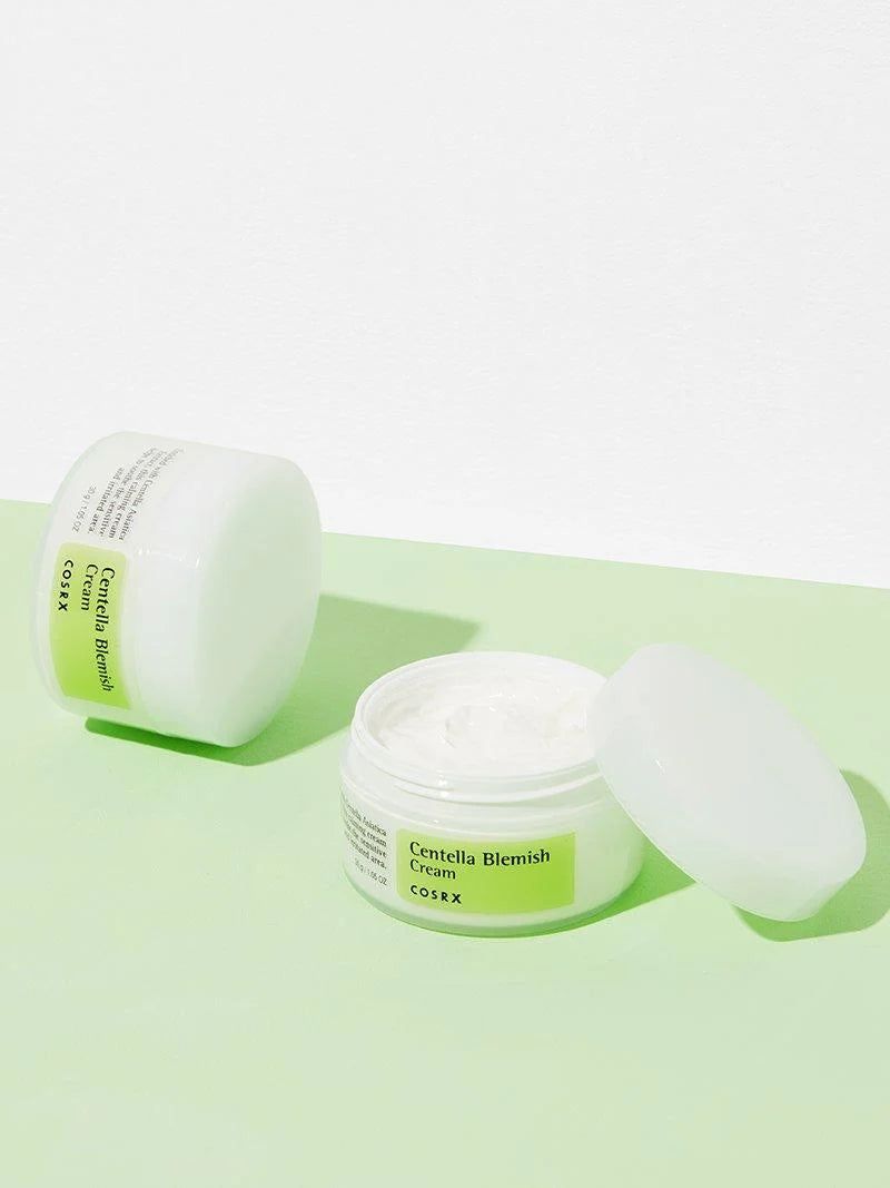 COSRX Centella Blemish Cream surrounded by fresh Centella Asiatica leaves, emphasizing the natural soothing ingredients.