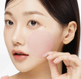 Woman using Medicube PDRN Pink Collagen toning gel toner pad 70 pads to gently wipe her cheek for elasticity and hydration.