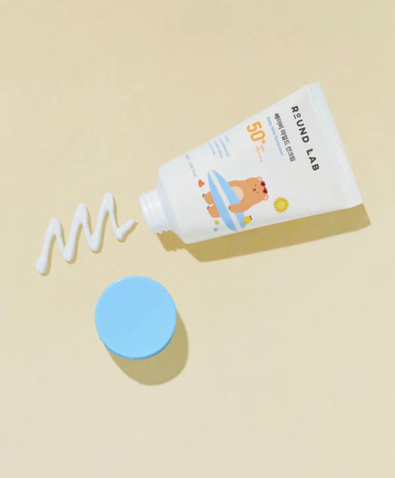 Applying Round Lab Baby Mild Sun Cream SPF 50 PA on baby's cheek