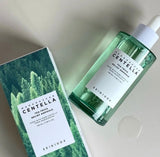 Close up of the SKIN1004 Tea Trica Relief Ampoule dropper dispensing the lightweight serum onto the back of a hand.