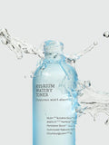 A clear drop of the watery toner Cosrx formula on skin, demonstrating its lightweight, non-sticky hydration texture.